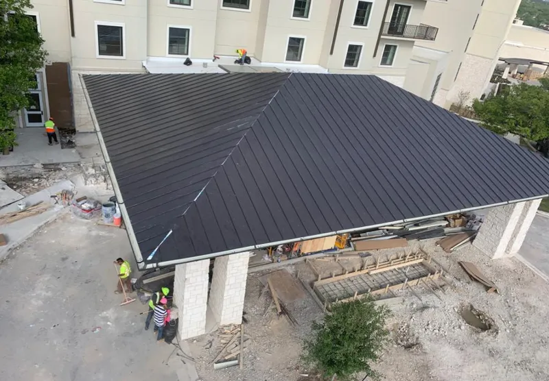 Metal roofing installation team working on a commercial building in Robinwood